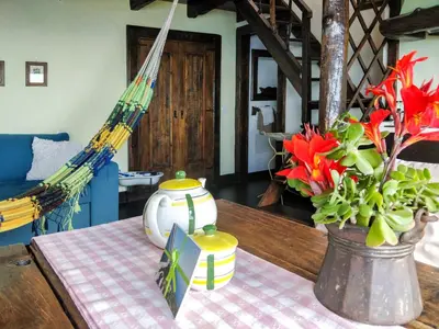 a table with a vase and flowers on a table at Calhau Grande in Arco da Calheta