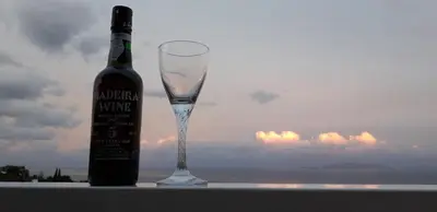 a bottle of wine sitting next to a wine glass at Villa SCIROCCO Madeira - Ocean View in Machico