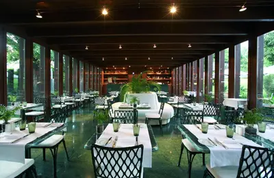 a restaurant with white tables and chairs and windows at Quinta da Casa Branca - Small Luxury Hotels of the World in Funchal