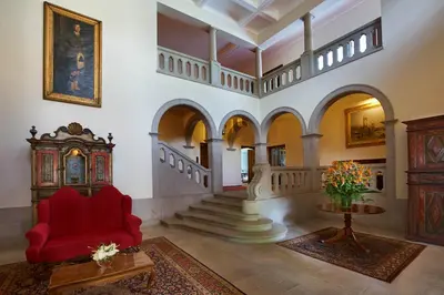 a living room with a red chair and a table at Quinta da Casa Branca - Small Luxury Hotels of the World in Funchal