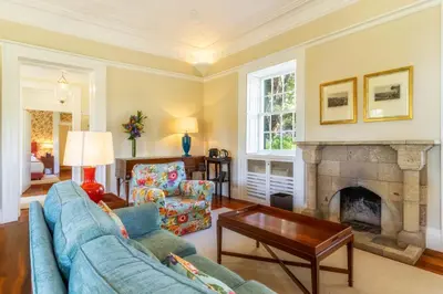 a living room with a blue couch and a fireplace at Quinta da Casa Branca - Small Luxury Hotels of the World in Funchal