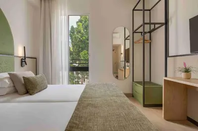 a bedroom with a large white bed and a mirror at The Editory Garden Carmo Funchal in Funchal
