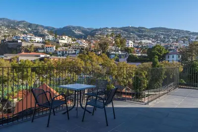 a table and chairs on a balcony with a view at The Editory Garden Carmo Funchal in Funchal