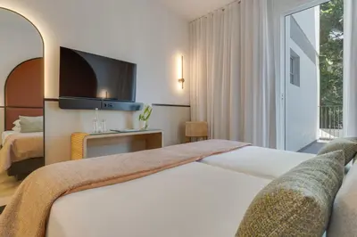 a hotel room with a bed and a television at The Editory Garden Carmo Funchal in Funchal