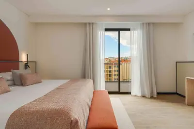 a bedroom with a large bed and a large window at The Editory Garden Carmo Funchal in Funchal