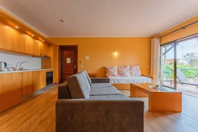 a living room with a couch and a bed at Quinta Splendida Wellness & Botanical Garden in Caniço