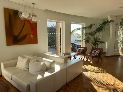 a living room with a white couch and a painting at Vila Luz in Luz