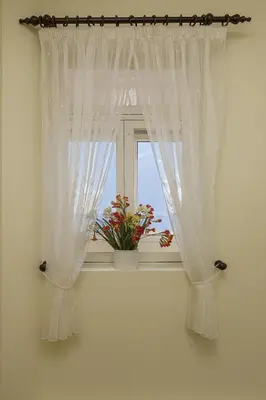 a window with white curtains and a potted plant at Funchal Window by Homie in Funchal