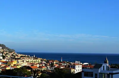 a view of a city with the ocean in the background at Funchal Window by Homie in Funchal