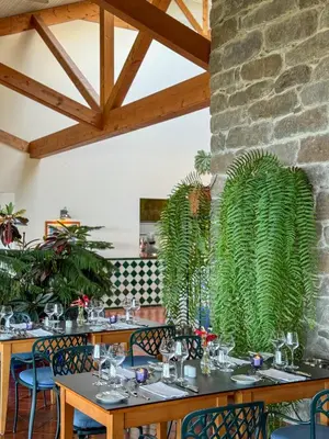 a dining room with tables and chairs with plants at Albatroz Beach & Yacht Club in Santa Cruz