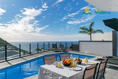 a table with fruit on it next to a swimming pool at OurMadeira - Calheta Charm in Calheta