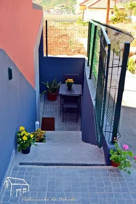 a set of stairs with a table and flowers at Palheirinho da Achada in Arco da Calheta