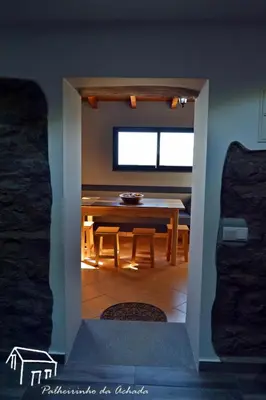 a dining room with a table and a table and chairs at Palheirinho da Achada in Arco da Calheta