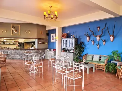 a restaurant with tables and chairs and a blue wall at Villa Alto Boutique Hotel in Ponta do Sol