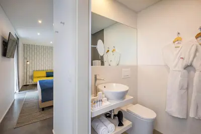 a white bathroom with a sink and a mirror at Allegro Madeira - Adults Only in Funchal
