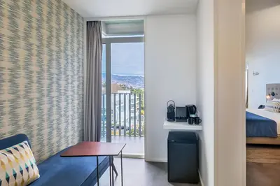a hotel room with a bed and a balcony at Allegro Madeira - Adults Only in Funchal