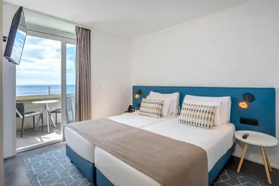 a bedroom with a large bed with a view of the ocean at Allegro Madeira - Adults Only in Funchal