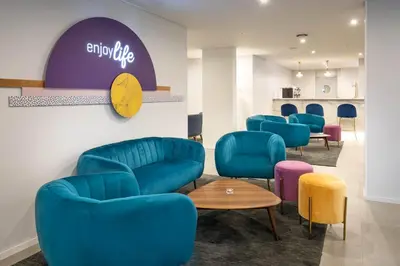 a waiting room with blue chairs and a table at Allegro Madeira - Adults Only in Funchal