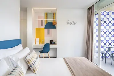 a bedroom with a bed and a desk with a chair at Allegro Madeira - Adults Only in Funchal