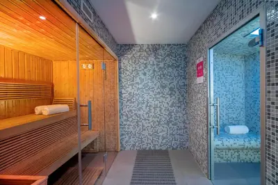 a bathroom with a shower and a glass door at Allegro Madeira - Adults Only in Funchal