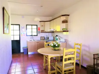 a kitchen and dining room with a table and chairs at Apartamentos Quinta Mae dos Homens in Funchal