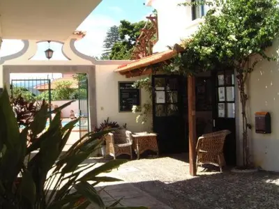 a patio with two chairs and a table in a building at Apartamentos Quinta Mae dos Homens in Funchal