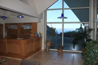a lobby with a counter and a large window at Eira do Serrado - Hotel & Spa in Curral das Freiras