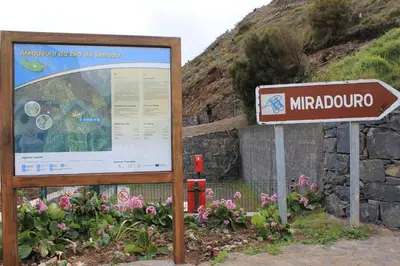 a sign in front of a mountain with flowers at Eira do Serrado - Hotel & Spa in Curral das Freiras