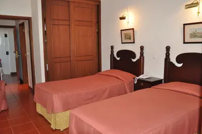a hotel room with two beds and a door at Vila Marta in Funchal