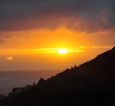 a sunset over the ocean from a hill at Vila Marta in Funchal