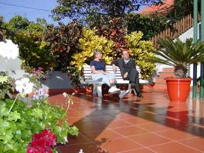 two people sitting on a bench in a garden at Vila Marta in Funchal