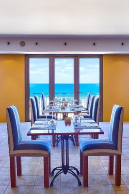 a dining room with a long table and chairs at Hotel Torre Praia in Porto Santo