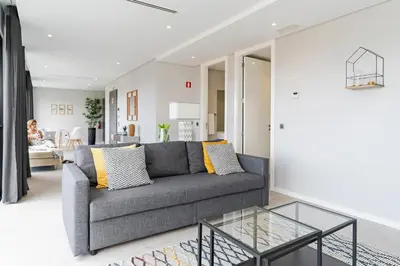 a living room with a gray couch and a glass table at Funchal Lux I by An Island Apart in Funchal