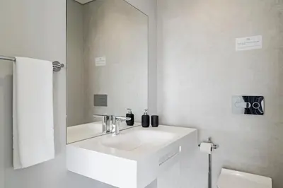 a white bathroom with a sink and a mirror at Funchal Lux I by An Island Apart in Funchal