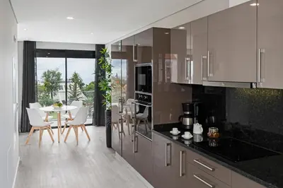 a kitchen with white cabinets and a table and chairs at Funchal Lux I by An Island Apart in Funchal
