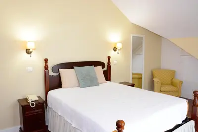 a bedroom with a large bed and a chair at Solar de Boaventura in Boaventura