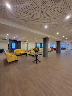 a large lobby with yellow couches and a table at Hotel Royal Orchid in Caniço