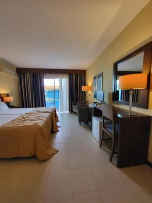 a hotel room with a bed and a desk with a computer at Hotel Roca Mar in Caniço