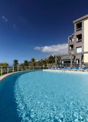 a large swimming pool in front of a building at Hotel Escola in Funchal