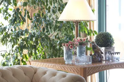 a table with a lamp and flowers on it at Hotel Escola in Funchal