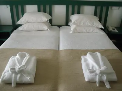 two white towels on a bed with pillows at Hotel Escola in Funchal