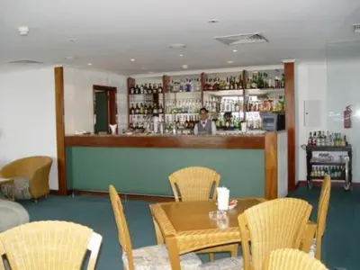 a restaurant with a table and chairs and a bar at Hotel Escola in Funchal