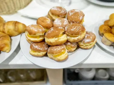 a pile of donuts on a plate on a shelf at Zarco B&B Bed & Breakfast in Funchal