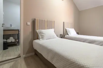 a bedroom with two beds with white sheets at Zarco B&B Bed & Breakfast in Funchal
