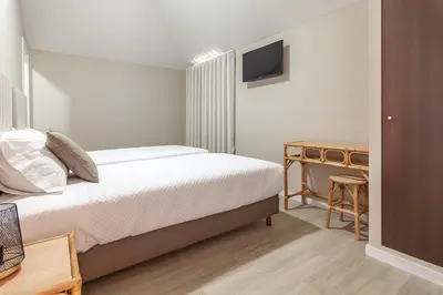 a bedroom with a bed and a desk with a television at Zarco B&B Bed & Breakfast in Funchal