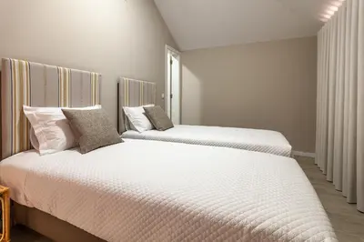 two beds in a bedroom with white sheets and pillows at Zarco B&B Bed & Breakfast in Funchal