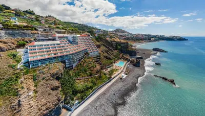 an aerial view of a hotel on a cliff next to the ocean at Miramar Apartment with pool by Holiday Rental Madeira in Funchal