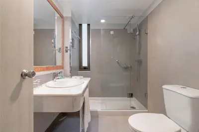 a bathroom with a sink and a shower and a toilet at Enotel Magnólia in Funchal