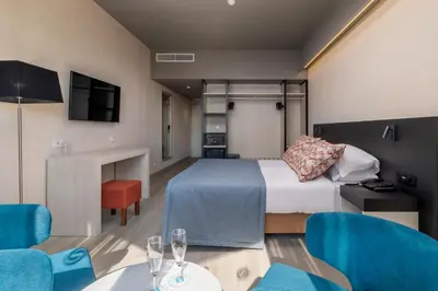 a hotel room with a bed and a table and chairs at Enotel Magnólia in Funchal