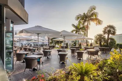 a restaurant with tables and chairs and umbrellas at Enotel Magnólia in Funchal